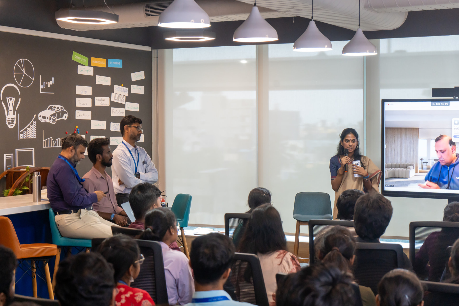 Speaker addressing the audience with a remote participant on the display