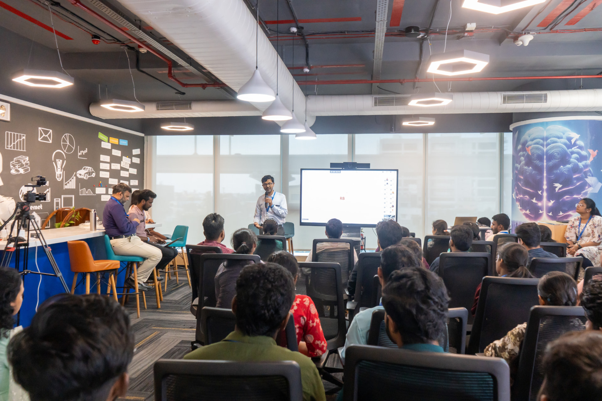 Alexandria AI launch session with a presenter addressing a seated audience